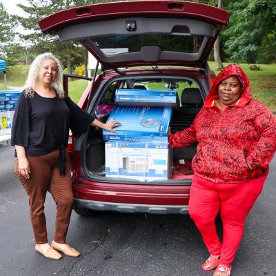 LaVonne (left) helps her client Jateir (right) pick up fans and an air conditioner.  
