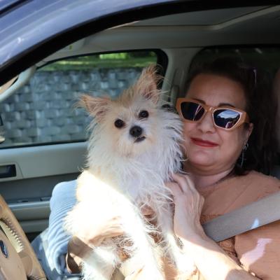 Rhonda and her dog sitting in their car at a HEAP air conditioner distribution