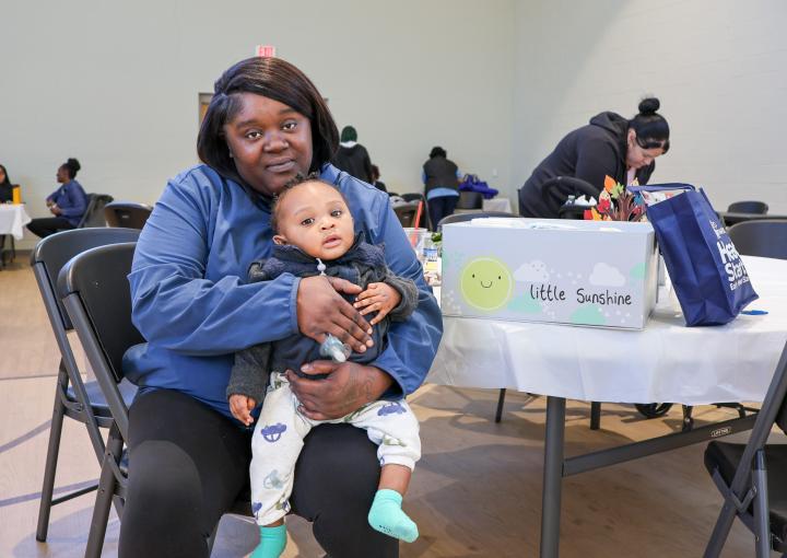 Sereniety holds her son at Step Forward's Safe Sleep Summit.