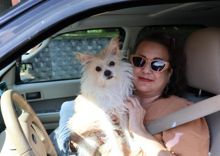 Rhonda and her dog sitting in their car at a HEAP air conditioner distribution